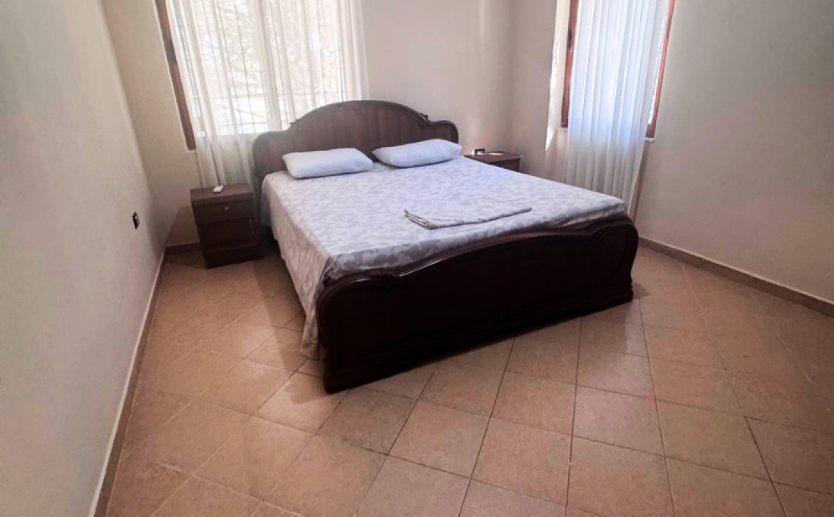 Apartment 2+kk for sale in Mali i Robit, Durrës, living room with kitchen Bedroom in seaside apartment for sale in Durrës, Albania Bathroom in 2-bedroom apartment Mali i Robit Balcony view from apartment in Durrës near the sea Exterior building 4th floor apartment Mali i Robit, Durrës Parking area in front of residential building in Durrës