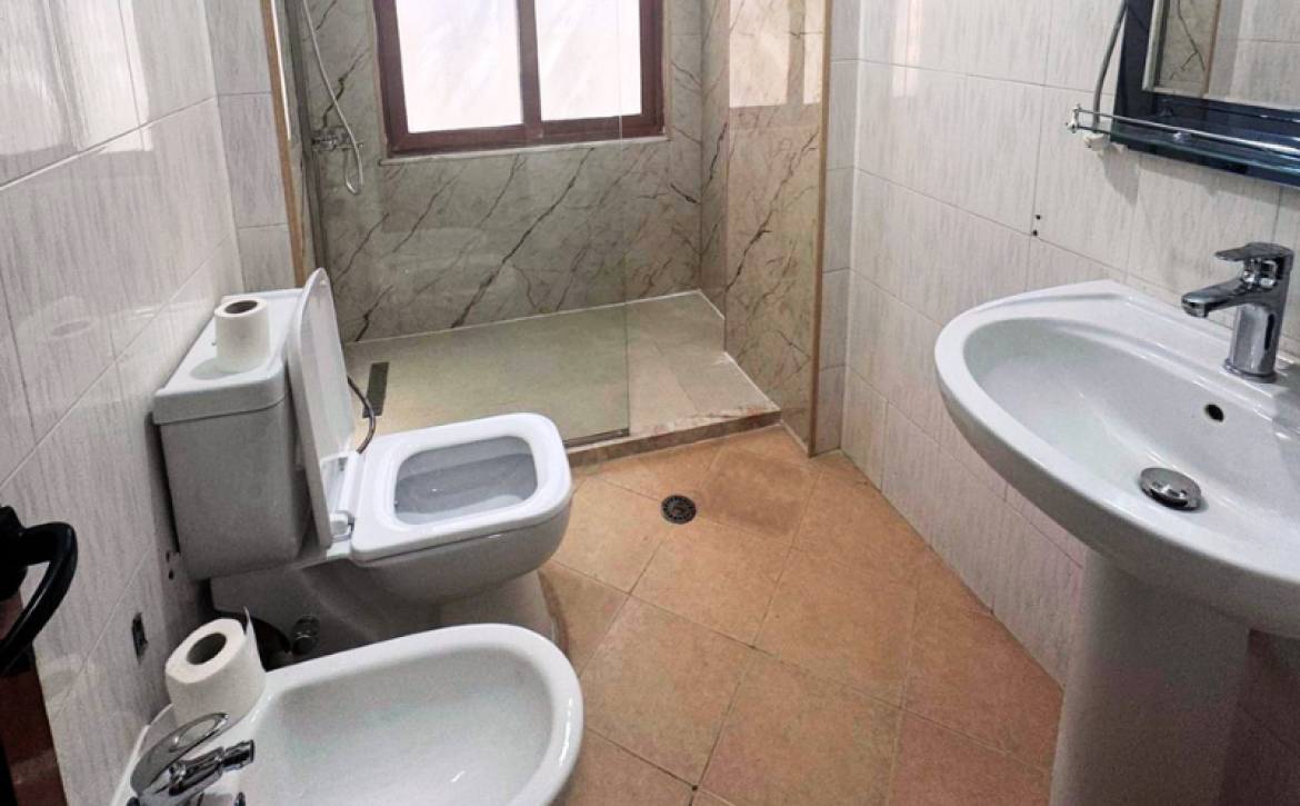 Apartment 2+kk for sale in Mali i Robit, Durrës, living room with kitchen Bedroom in seaside apartment for sale in Durrës, Albania Bathroom in 2-bedroom apartment Mali i Robit Balcony view from apartment in Durrës near the sea Exterior building 4th floor apartment Mali i Robit, Durrës Parking area in front of residential building in Durrës