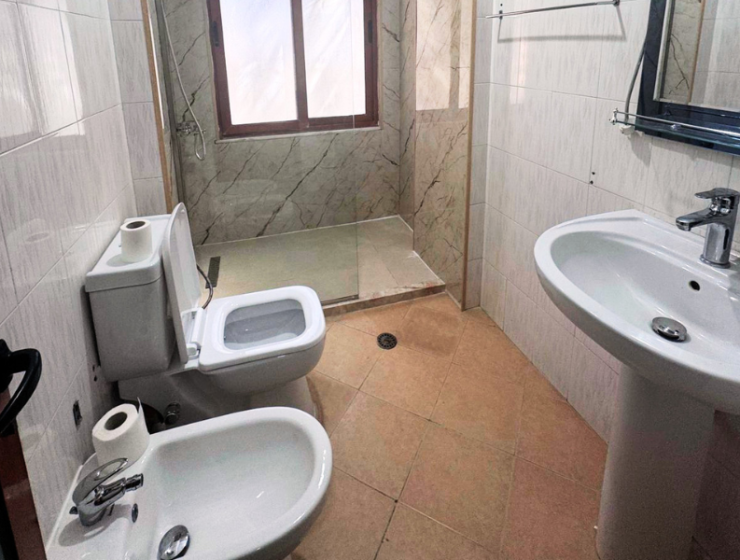 Apartment 2+kk for sale in Mali i Robit, Durrës, living room with kitchen Bedroom in seaside apartment for sale in Durrës, Albania Bathroom in 2-bedroom apartment Mali i Robit Balcony view from apartment in Durrës near the sea Exterior building 4th floor apartment Mali i Robit, Durrës Parking area in front of residential building in Durrës