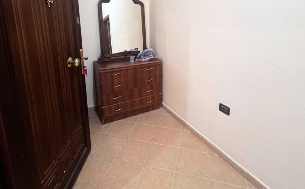Apartment 2+kk for sale in Mali i Robit, Durrës, living room with kitchen Bedroom in seaside apartment for sale in Durrës, Albania Bathroom in 2-bedroom apartment Mali i Robit Balcony view from apartment in Durrës near the sea Exterior building 4th floor apartment Mali i Robit, Durrës Parking area in front of residential building in Durrës
