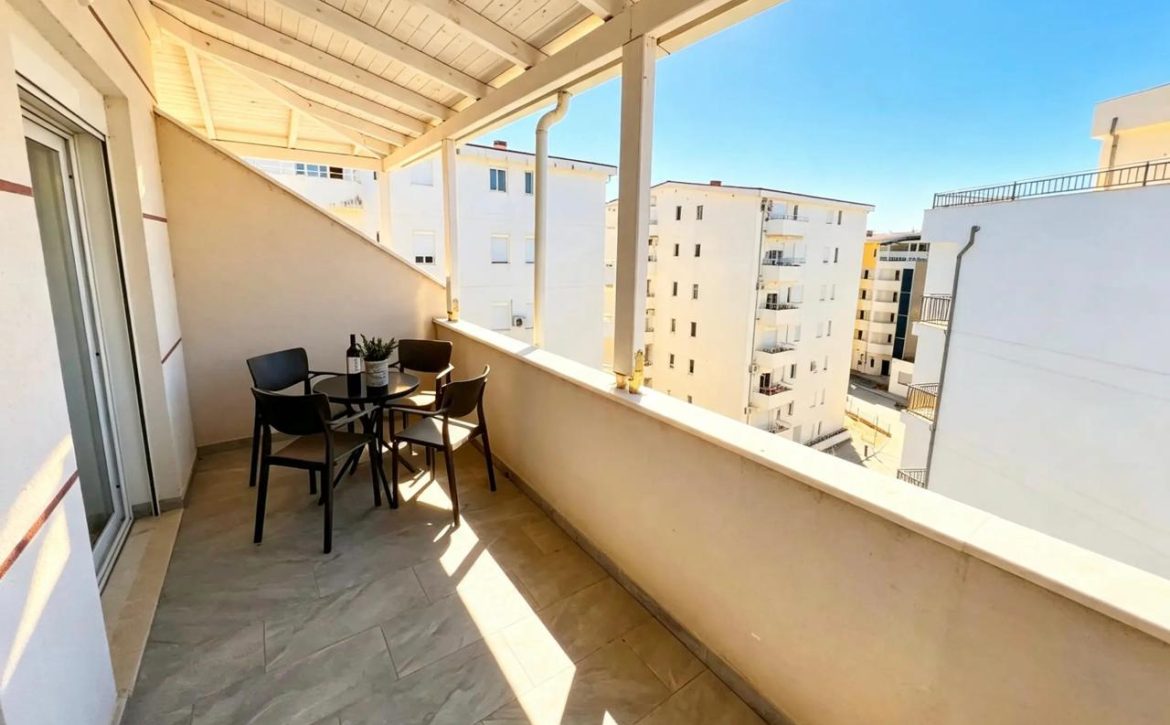 Spacious covered terrace with seating and view in Qerret apartment