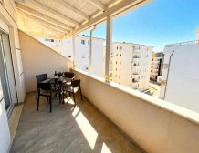 Spacious covered terrace with seating and view in Qerret apartment